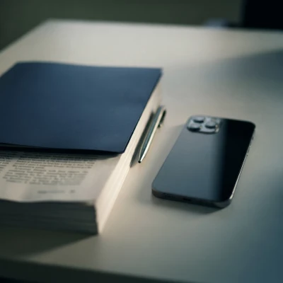 Telemóvel e bloco de notas sobre uma secretária